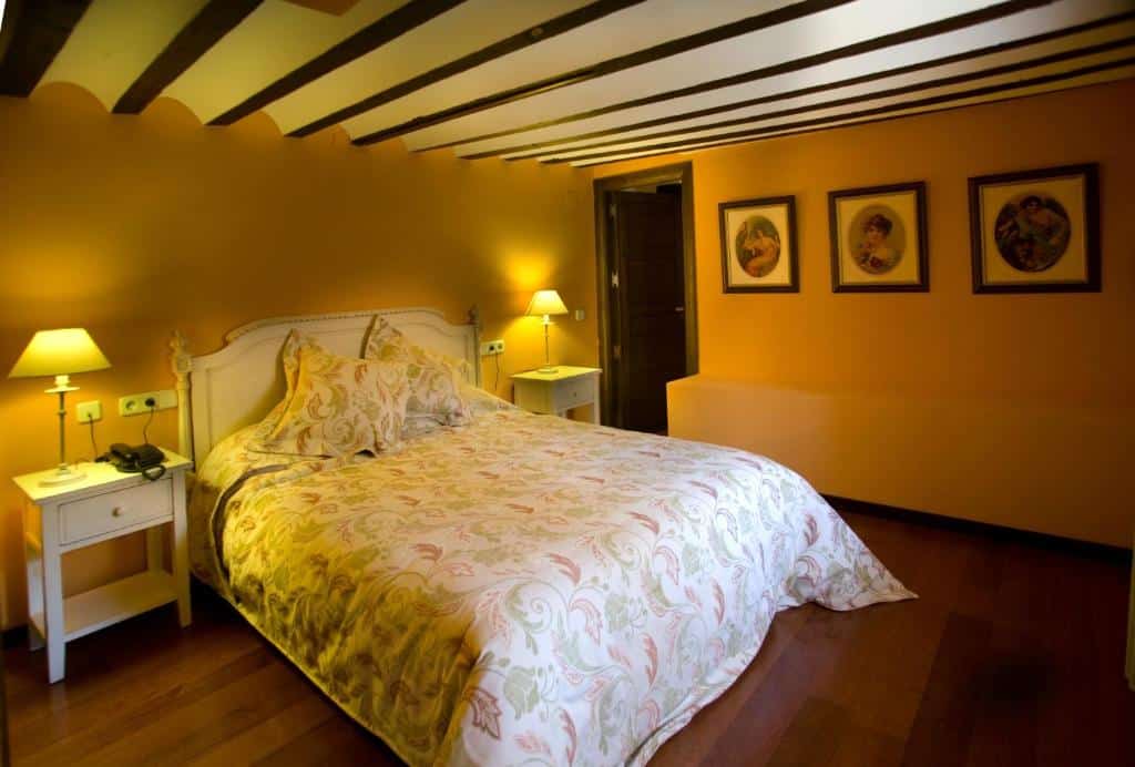 a bed with a white bedding and a lamp on the side auto_awesome Traducir del: inglés 49 / 5.000 Una cama con ropa de cama blanca y una lámpara al costado.